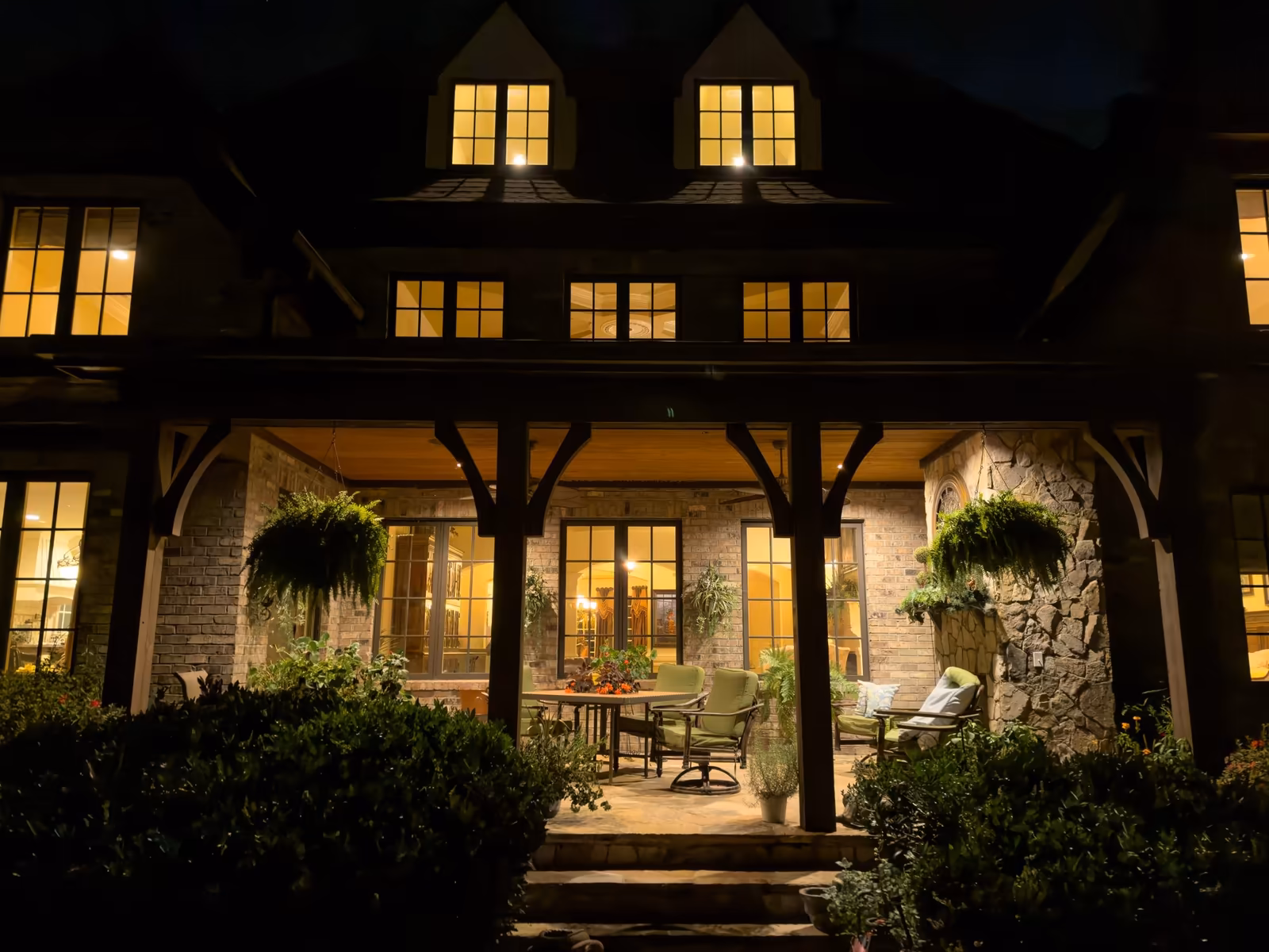 Covered loggia glowing warmly against the estate at night