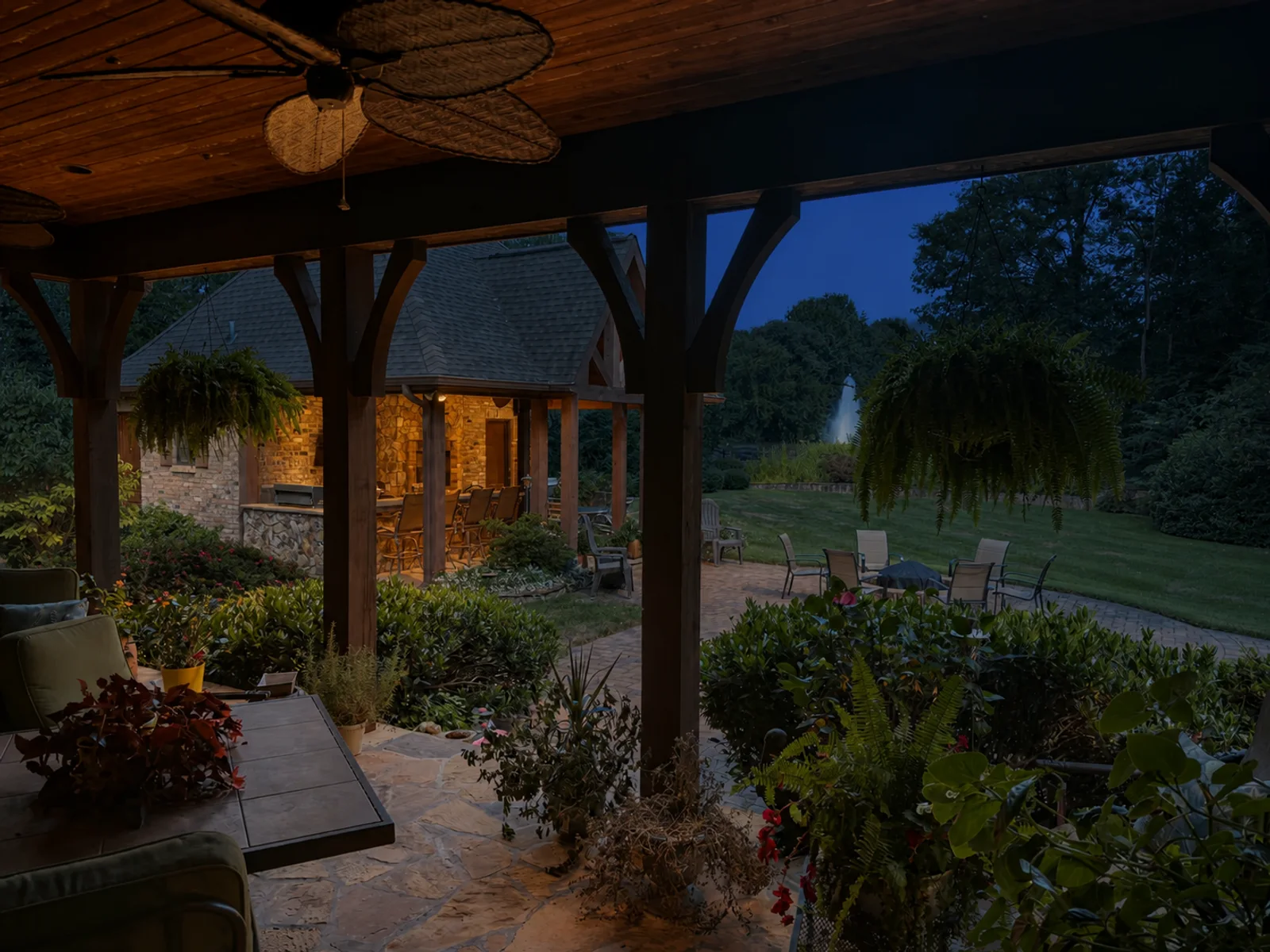 AI evening lighting interpretation of the same view of a timber lanai looking toward a garden pavilion