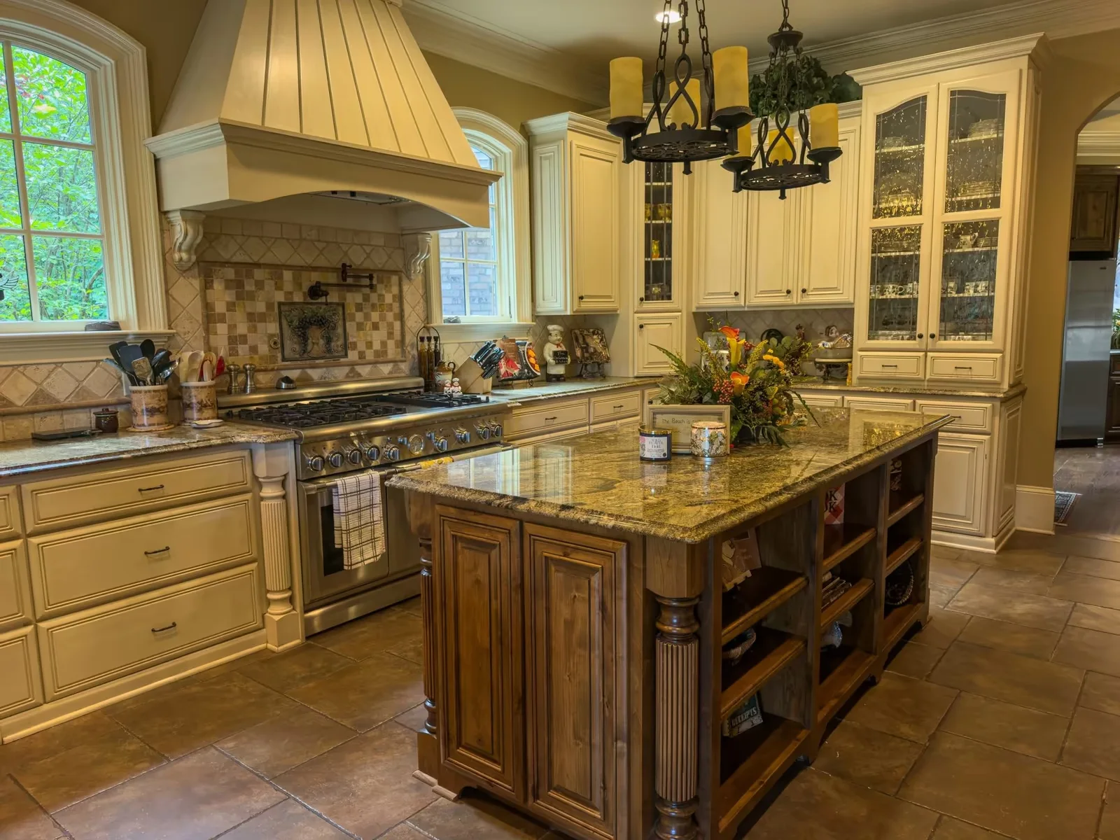 Original daylight photograph of an ivory kitchen with a timber island and two chandeliers