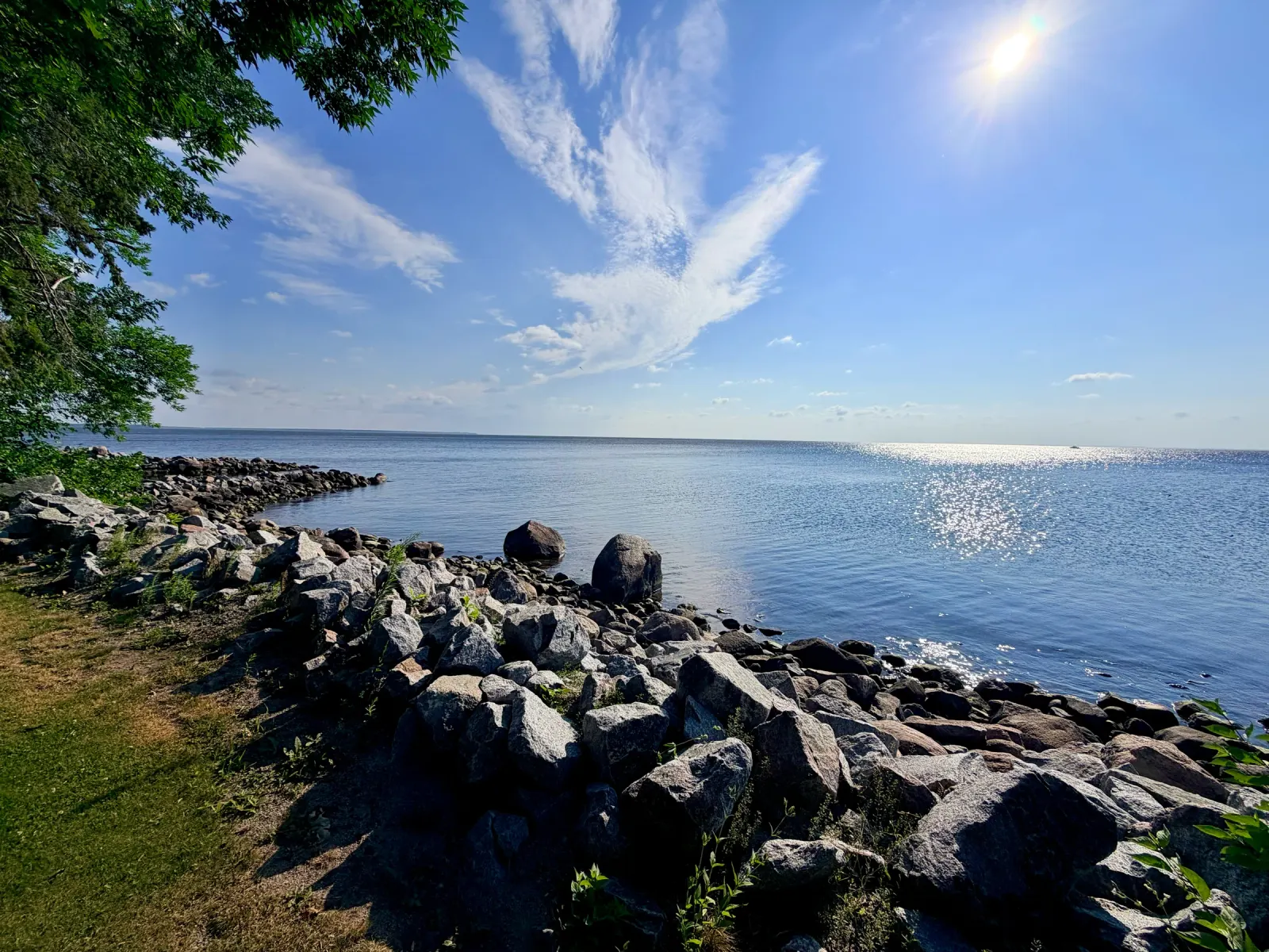 Rocky lakeshore under a summer sky, photographed by Paul Mattson